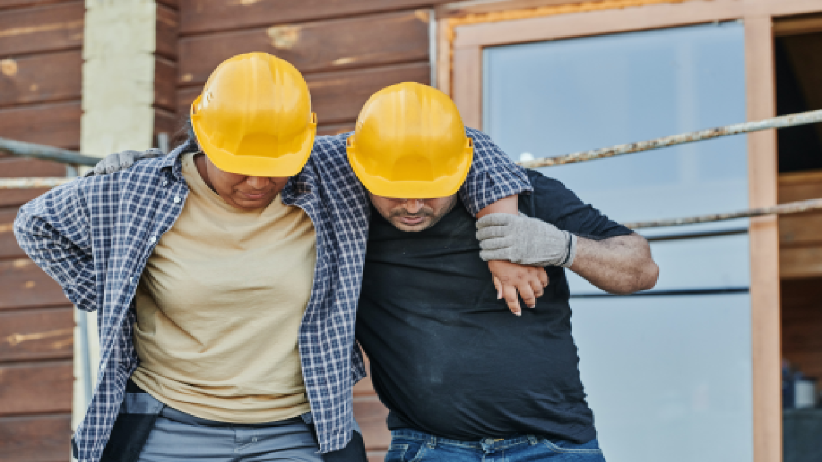 Construction workers helping each other walk after being injured.