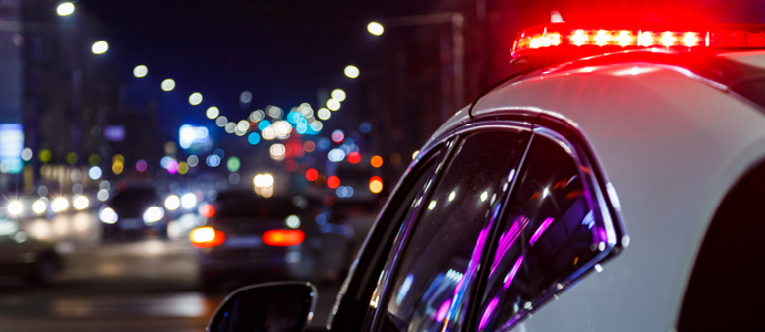 police car lights at night in city with selective focus and blurry car traffic