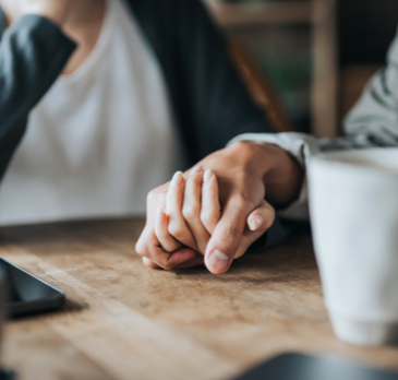 Two people holding hands, comforting each other after an accident.