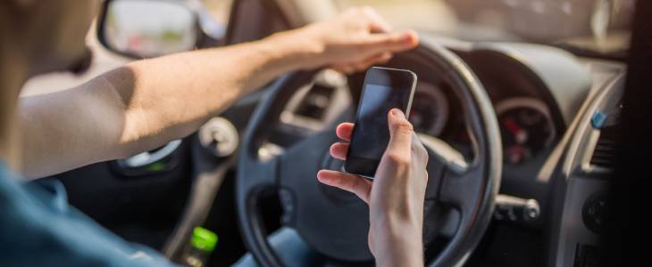 Man is texting on his cellphone while driving