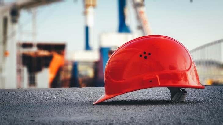 hard hat lays on the concrete floor of oil refinery