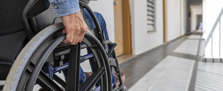 Man in wheelchair going through a hallway.