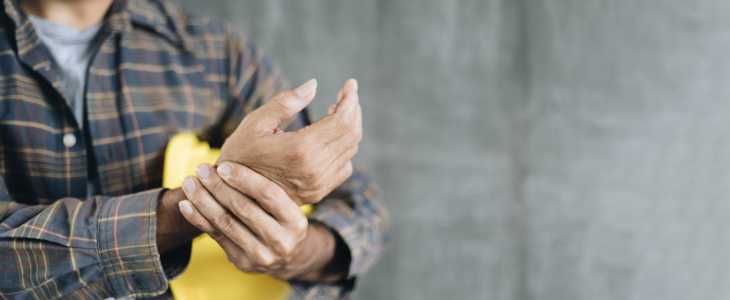 Construction working holding wrist due to overuse injury