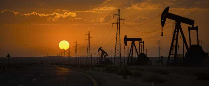 Oil wells and power lines on the side of the highway