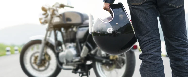 Person holds helmet by motorcycle on North Dakota road, related to personal injury lawyer