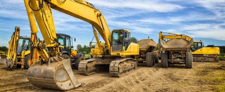 Excavators and dump trucks on North Dakota work site, related personal injury attorney