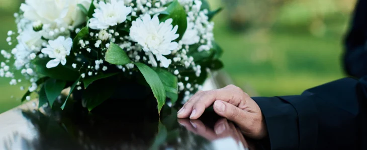 and rests on casket with flowers, wrongful death case in North Dakota