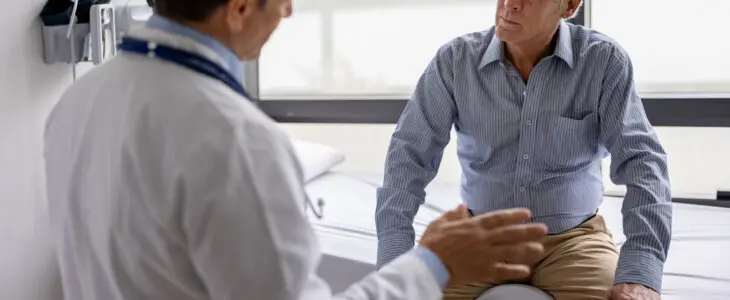 Latin American doctor talking to a patient in a consultaton at his office practice