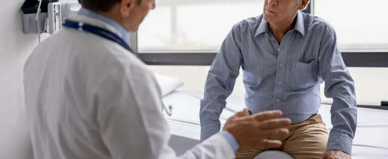 Latin American doctor talking to a patient in a consultaton at his office practice